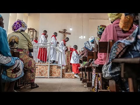 YouTube thumbnail showing the rapping priest engaging with youth in Kinshasa.