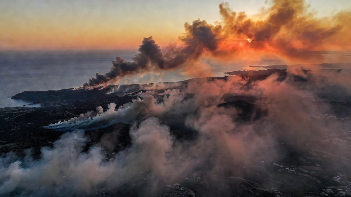 Aerial view of wildfire smoke across Mediterranean coastline during European heatwave, July 2026