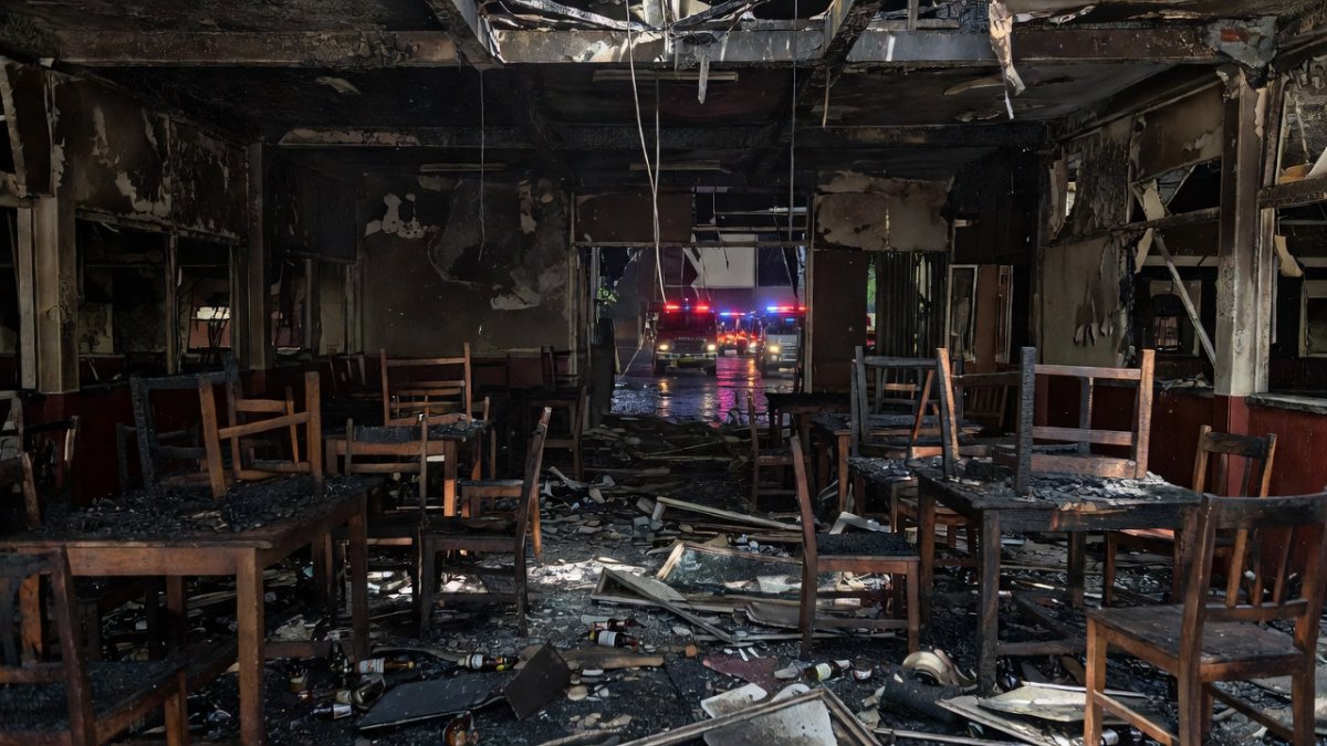 Charred interior of Rong Beer Na Lat Phrao beer hall showing damaged tables, chairs and collapsed ceiling after the July 2026 fire