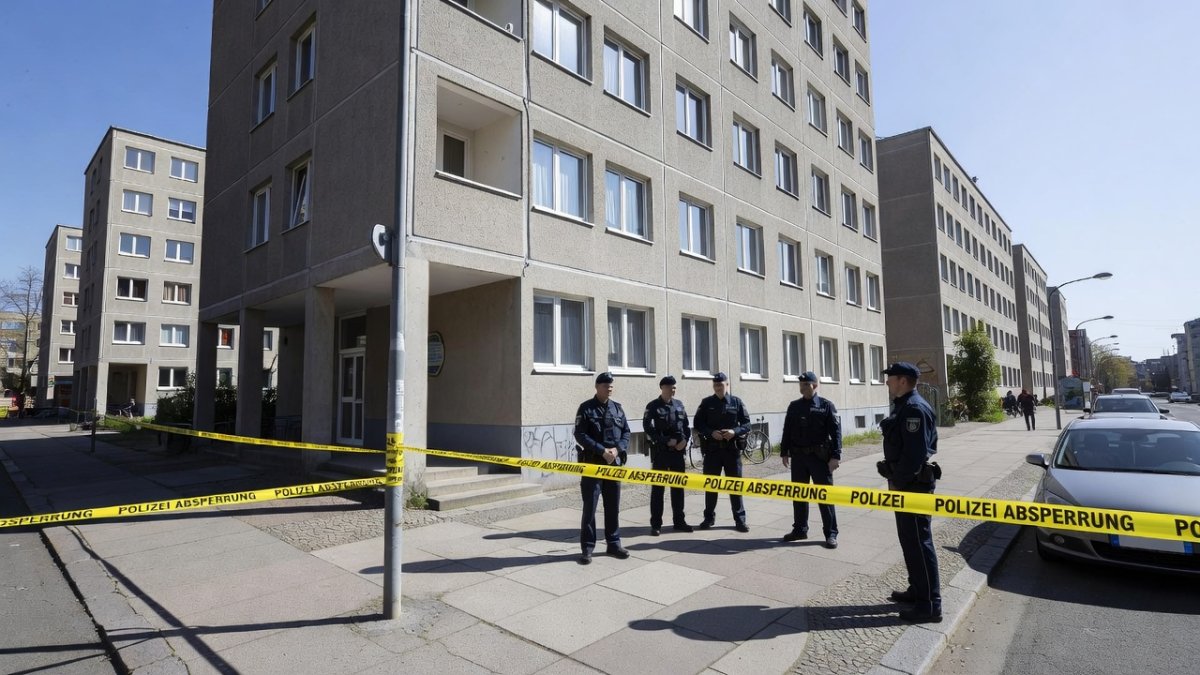 Berlin police officers at residential building in Tiergarten district, police tape visible
