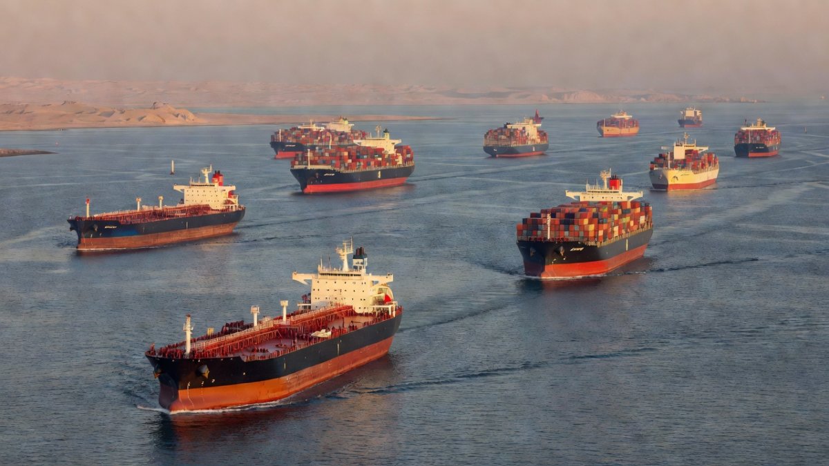 Wide shot of oil tankers navigating the Strait of Hormuz at sunrise