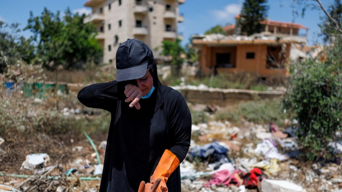 A Lebanese resident salvages the remains of her home destroyed in an Israeli strike in southern Lebanon (Reuters)