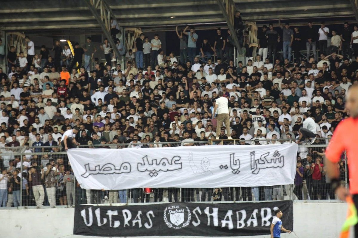 Palestinian club Shabab Al-Khaleel fans raise a banner thanking Egypt coach Hossam Hassan
