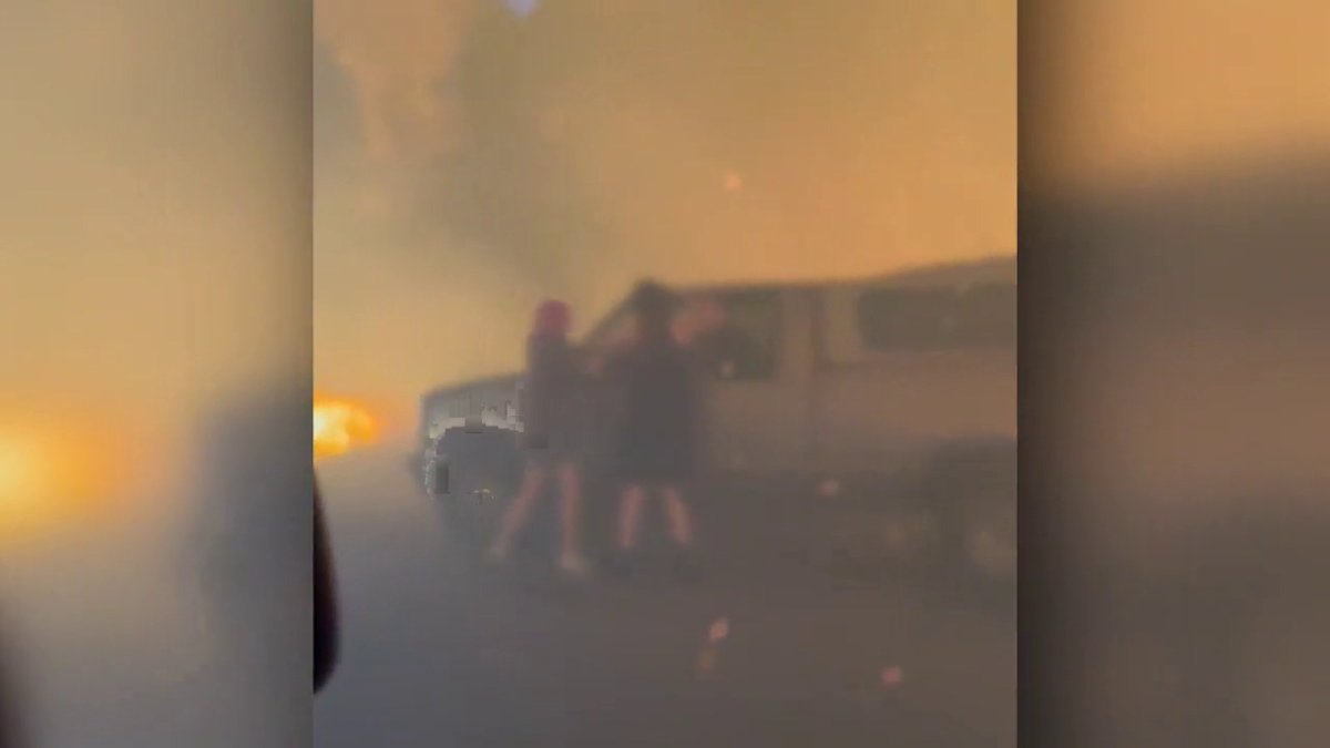 Residents rescuing dogs from a vehicle surrounded by flames in Faulder