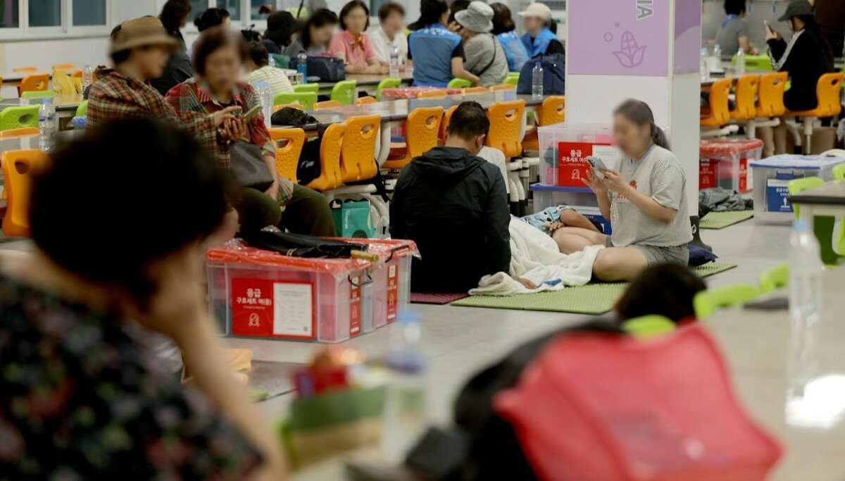 Residents displaced by flooding gather at a temporary shelter in Geoje