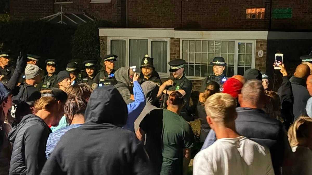 A group gathers outside suspected asylum seeker housing in Thetford