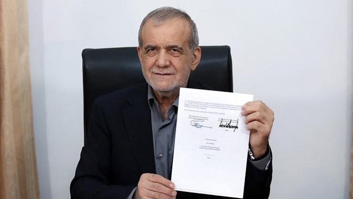 Iranian President Masoud Pezeshkian holds the Iran-US memorandum document during a news conference in Tehran