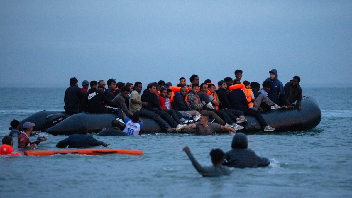 Migrants being brought ashore at Dover Western Docks by Border Force officials