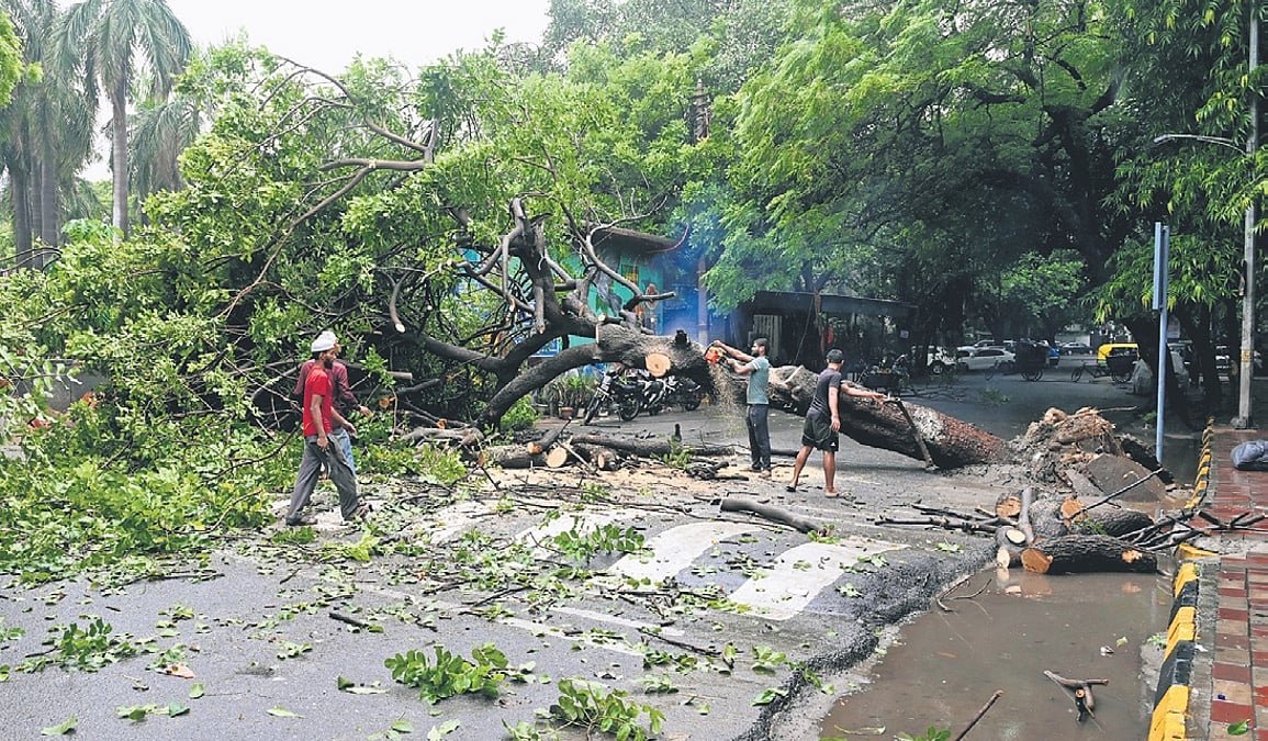 Commuters navigating a waterlogged street in Delhi