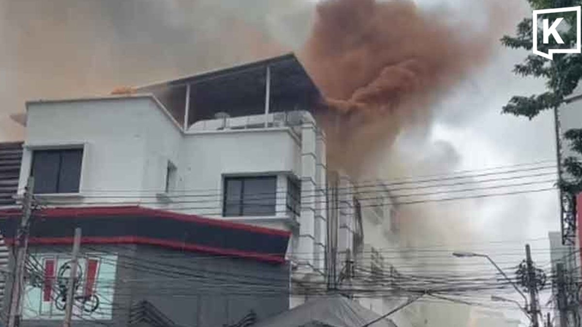 Rescue crews spray water on Khlong Thom Center as thick smoke billows from the building in Bangkok