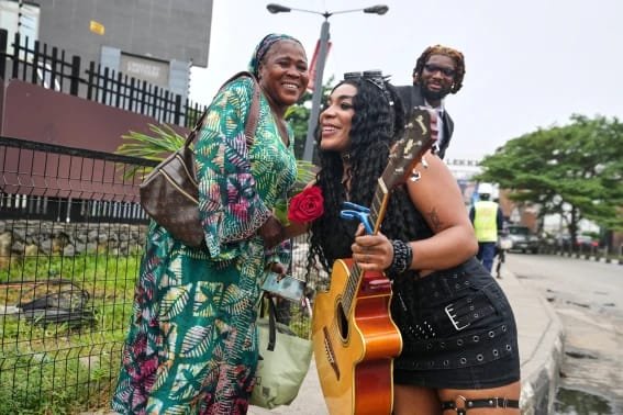 Clayrocksu and Machigold share a moment with a Lagos commuter