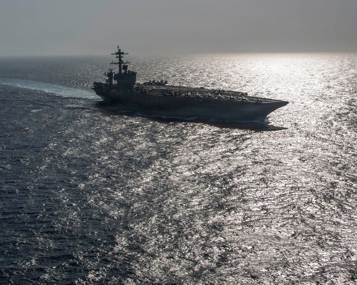 Sailors on the deck of USS Abraham Lincoln looking exhausted during extended deployment