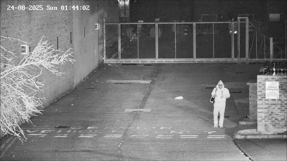Night-time CCTV image showing Simon Levy walking towards a car park exit in Tottenham