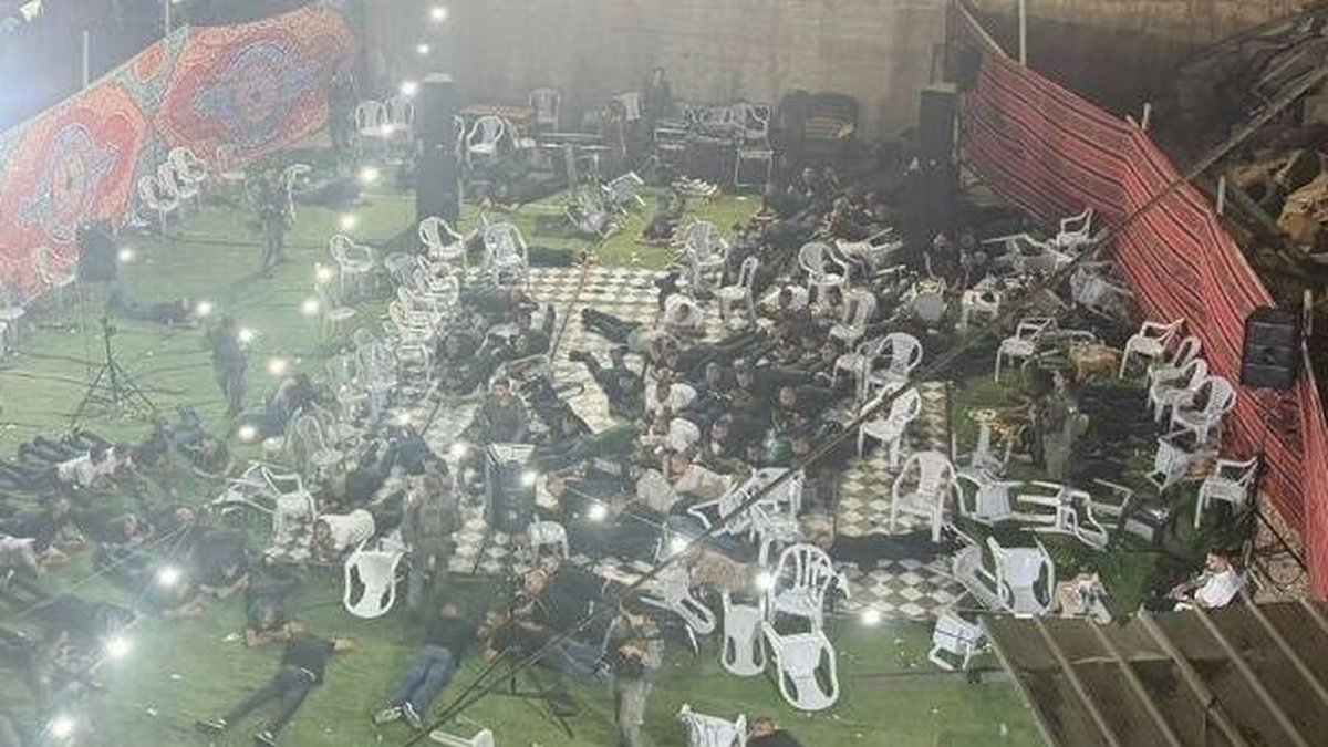 Guests lie face down among overturned chairs during a police raid on a henna party in Umm al-Fahm