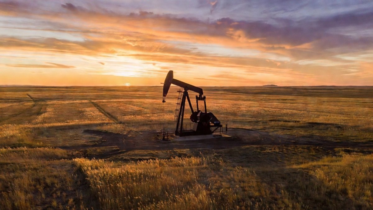 An Alberta oil pump jack against a prairie sunset, reflecting the province's energy-driven fiscal turnaround