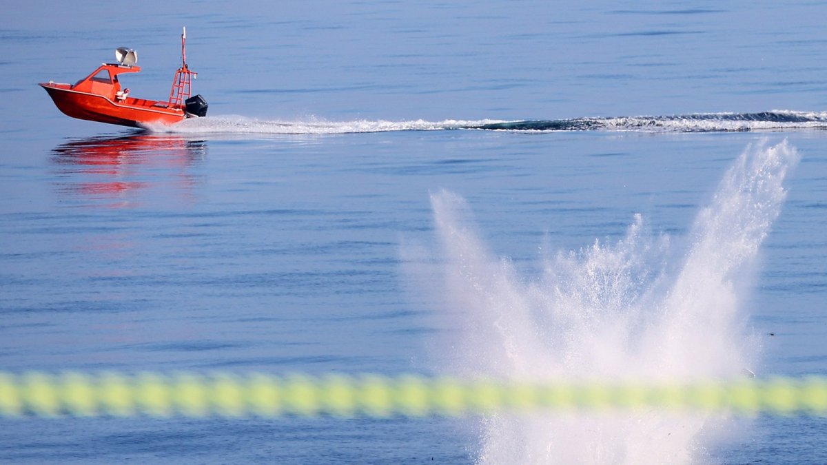 A domestically developed suicide drone falls toward the sea as an unmanned surface vessel target passes nearby during the failed maritime trial off Busan, Aug. 25, 2026