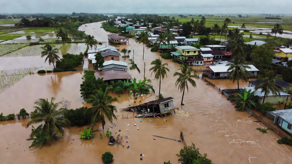 Aerial view of flooded Abra de Ilog, Occidental Mindoro with a riverside home collapsing into the water