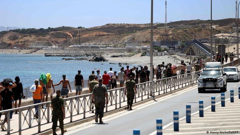 Migrants wait on the street in Ceuta as migration processing centers reach full capacity (Reuters)
