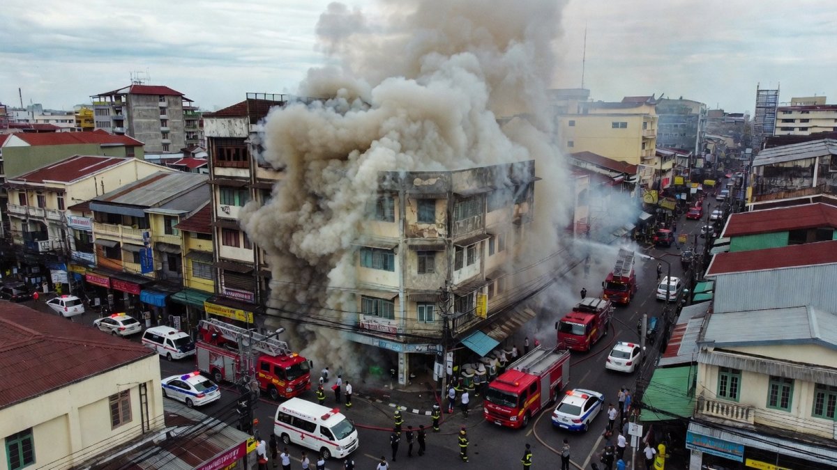 Aerial view of an old commercial district in Bangkok with smoke rising above buildings
