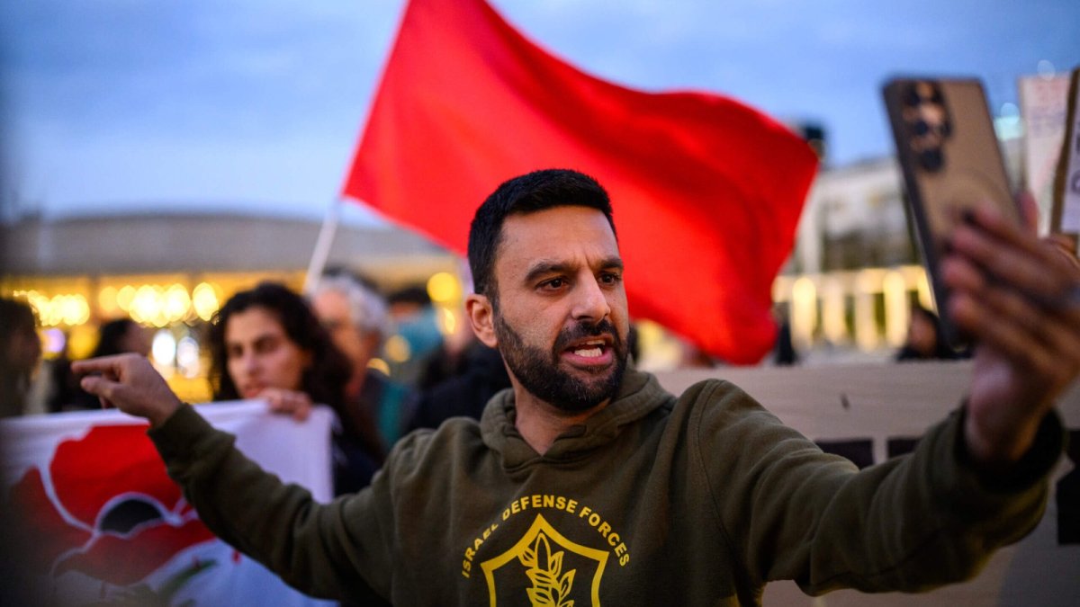 Yoseph Haddad films himself during a small anti-war protest in Tel Aviv