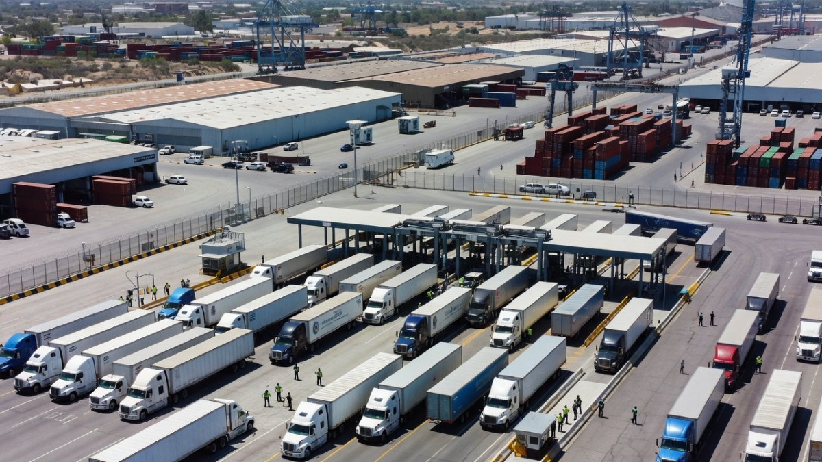 Cargo trucks at a US-Mexico border crossing trade corridor