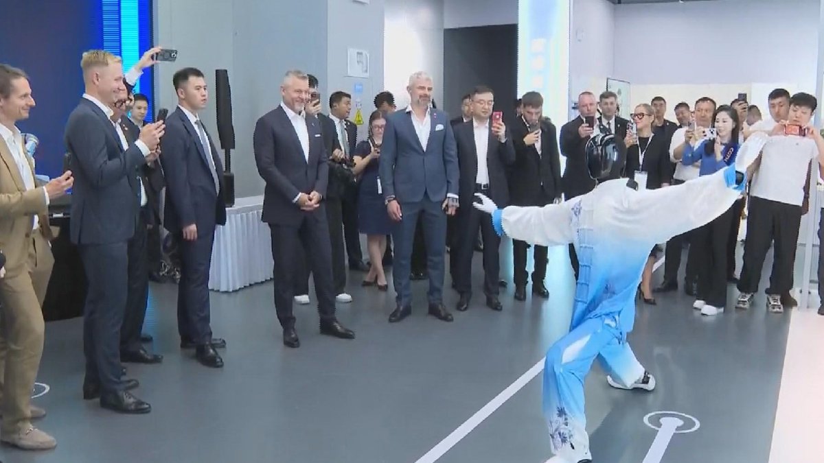 Slovak President Peter Pellegrini watches a humanoid robot performing tai chi at the Robot Mall in Beijing E-Town