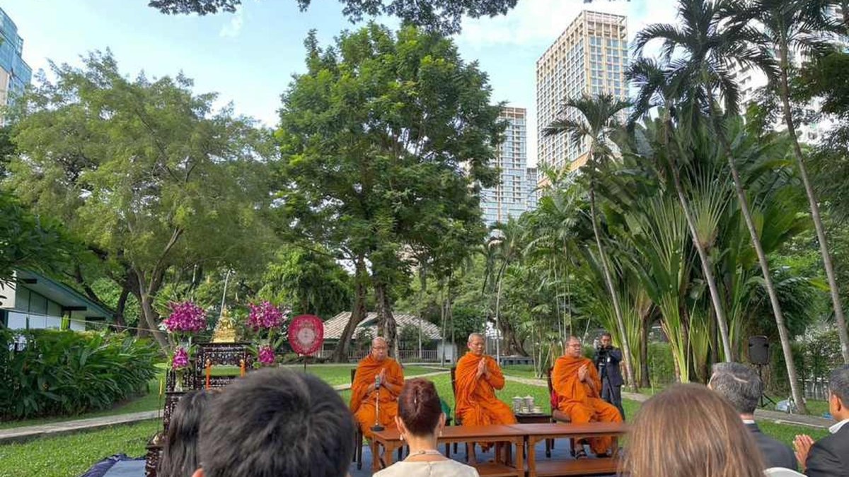 Buddhist monks in saffron robes leading the tree ordination ritual at the US ambassador's residence in Bangkok