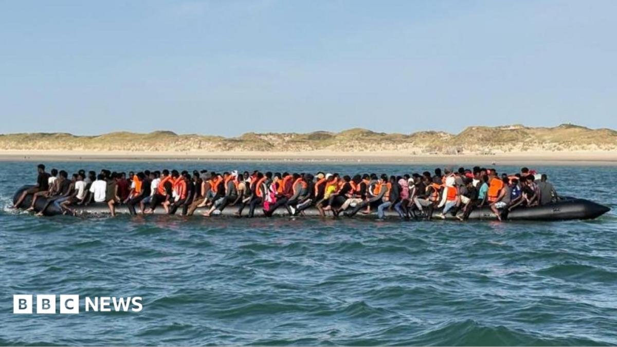 Overcrowded inflatable boat carrying migrants crossing the English Channel approaches Dover