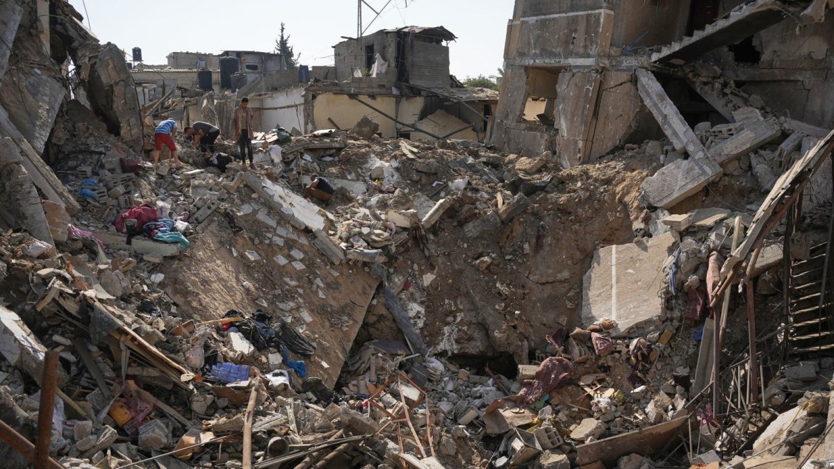 Palestinians salvage belongings from destroyed buildings in the central Gaza Strip, August 2026