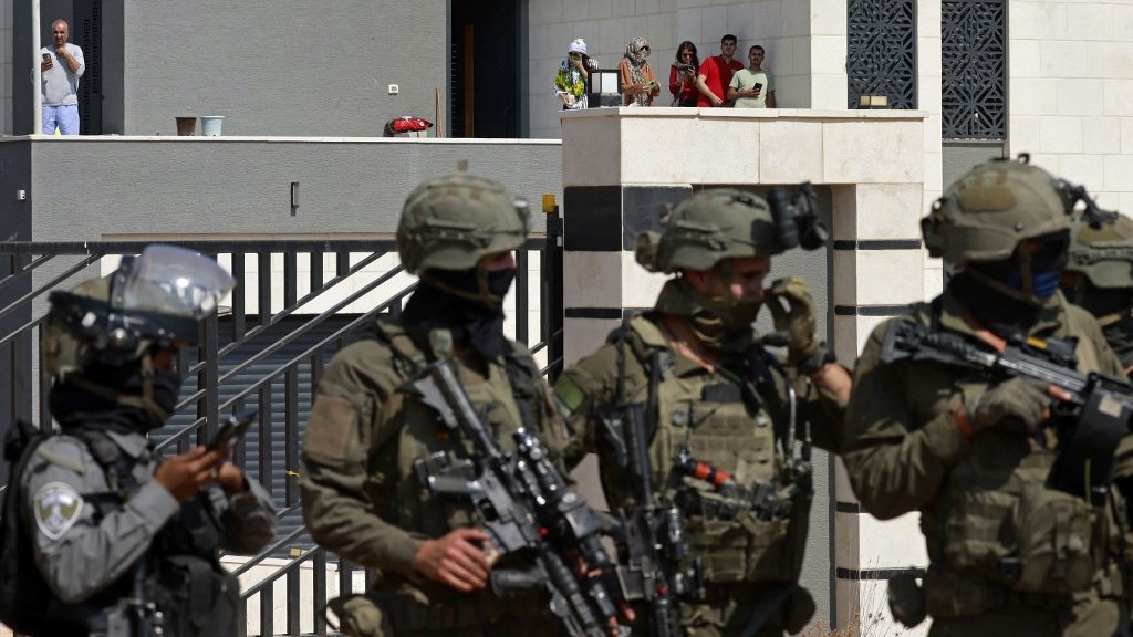 A Palestinian house besieged by Israeli settlers in Qusra, occupied West Bank (Jaafar Ashtiyeh/AFP)