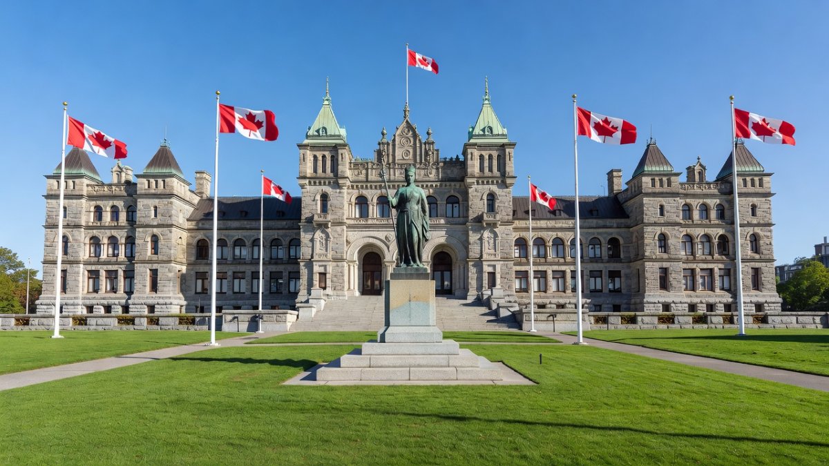 The British Columbia Legislature building in Victoria, with the B.C. and Canadian flags flying in the foreground.
