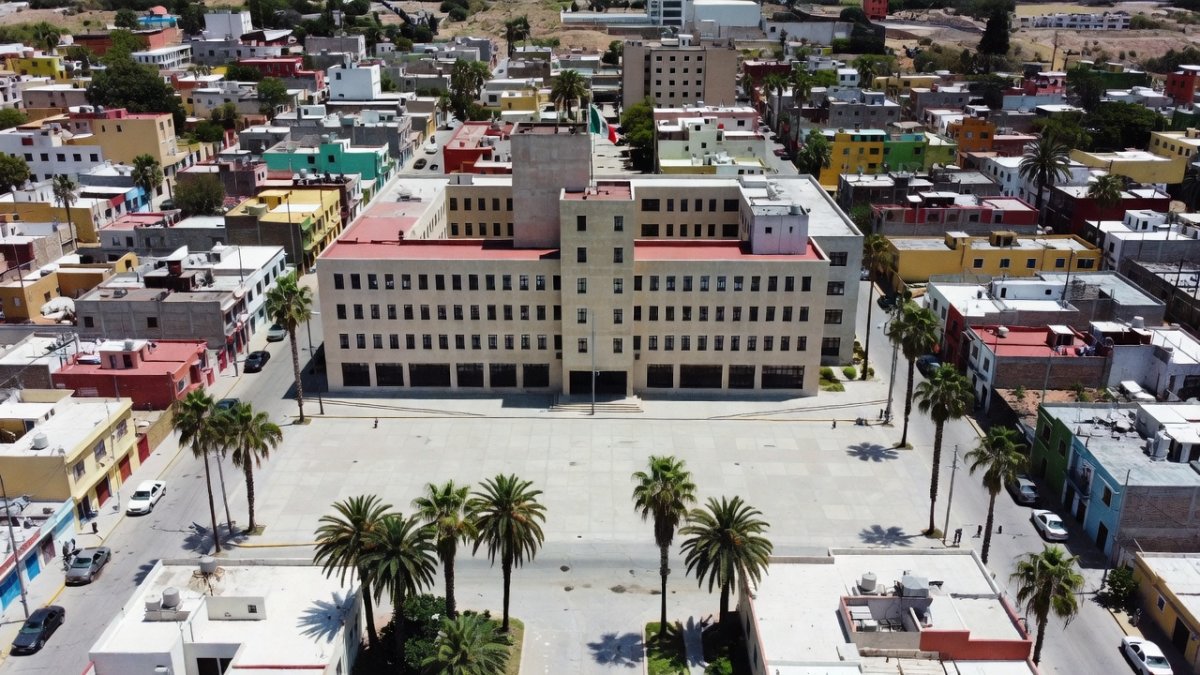 Aerial view of a Mexican border city government complex with palm trees and plaza