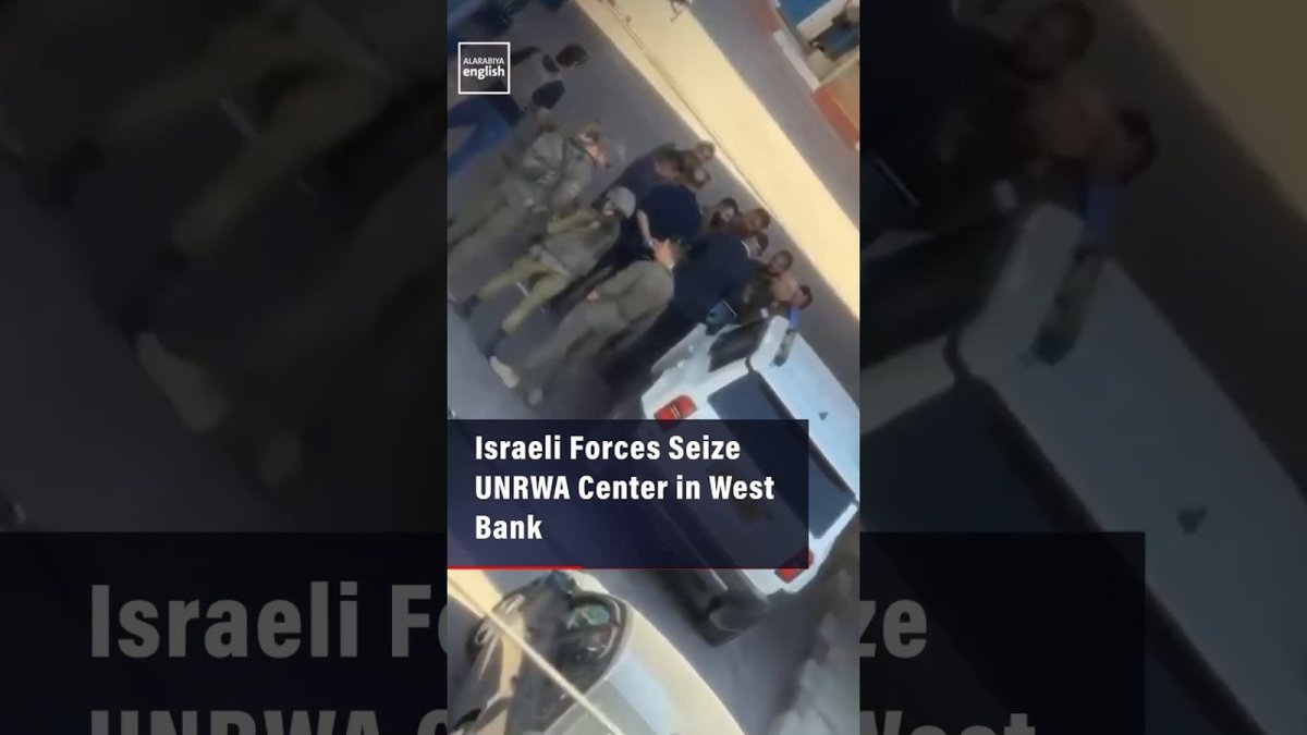 Palestinian residents and UNRWA staff watching the Israeli raid from a distance in Kafr Aqab