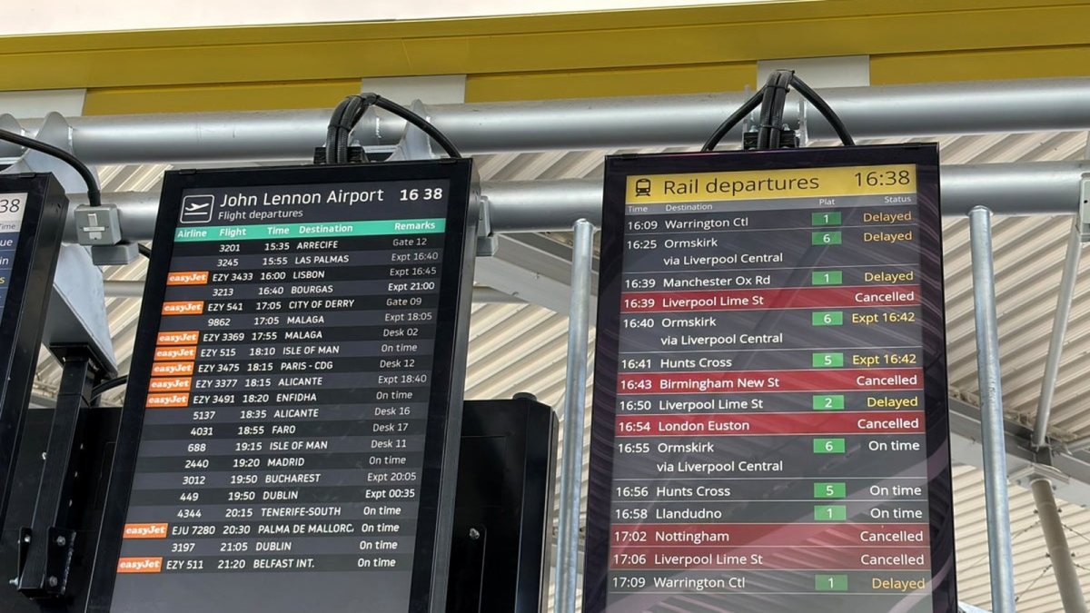 Commuters checking departure boards amid rail disruption in north-west England