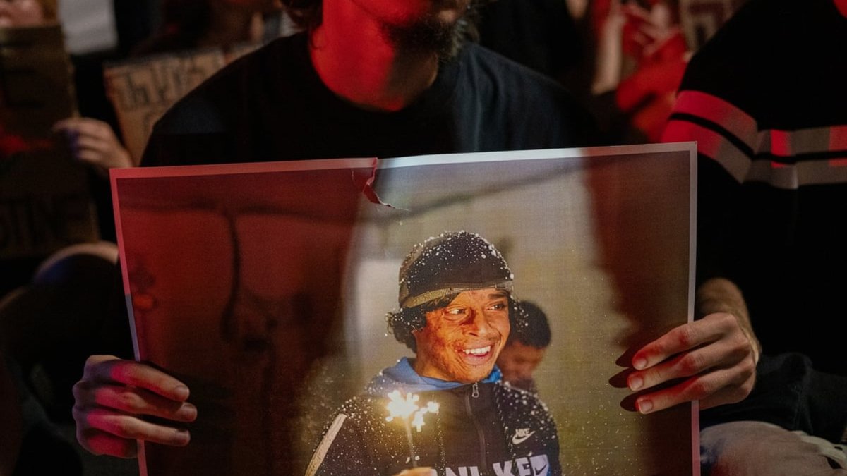 A demonstrator holds a photo of Awdah Hathaleen during a protest in Tel Aviv after his killing in 2025