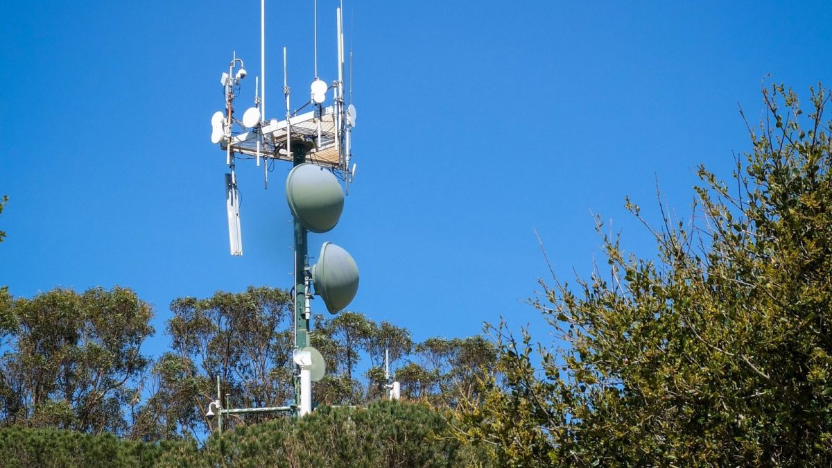 Telecommunication tower with cellular antennas against a blue sky