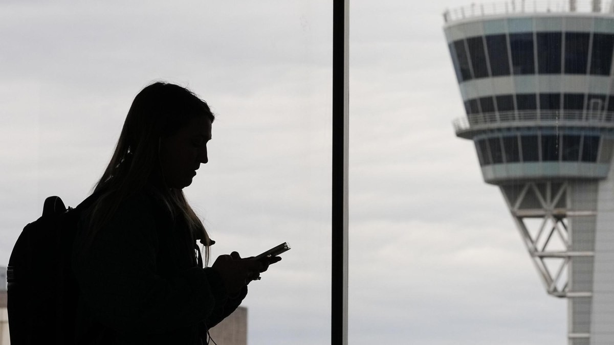 A traveller looks out towards an air traffic control tower at Philadelphia International Airport. Photo: AP Photo/Matt Rourke, File