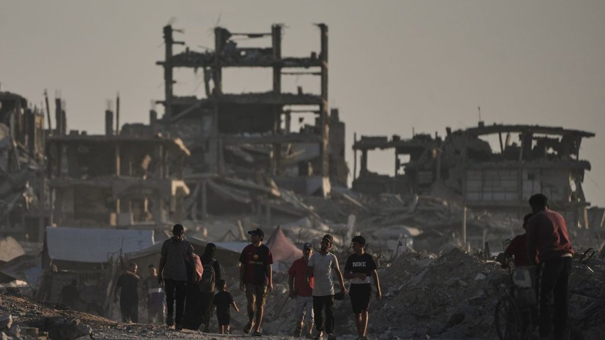 Displaced Palestinians walk through the rubble of the Gaza Strip