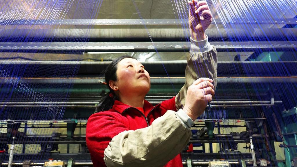 A worker monitors yarn production at a factory in Suzhou, eastern China