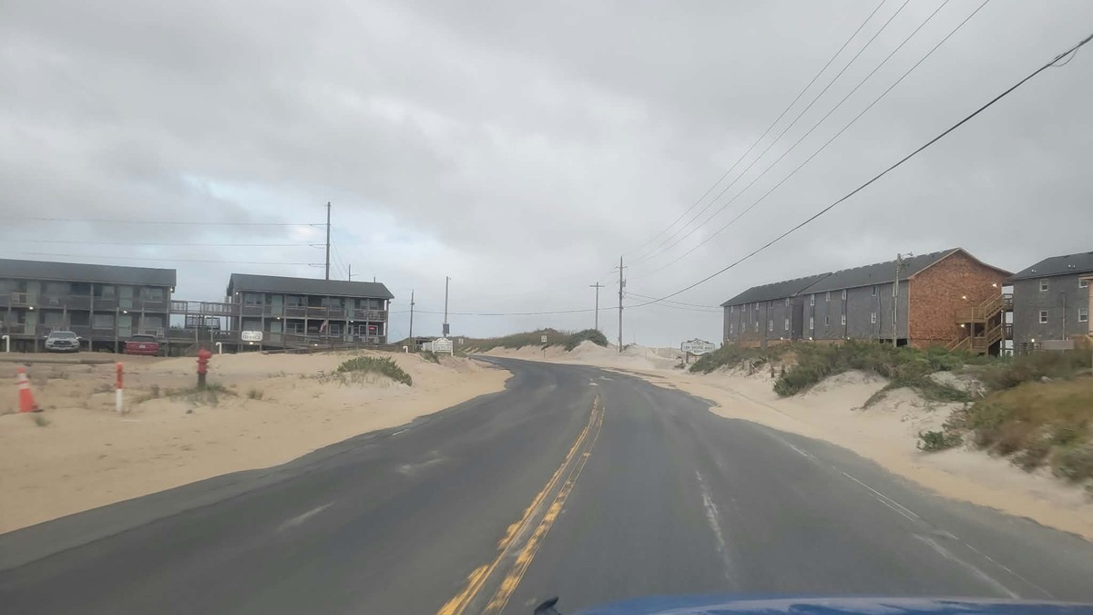 Wind-blown sand covers N.C. Highway 12 in northern Buxton, North Carolina, on Friday, 25 September 2026. Photo: Joy Crist / Island Free Press