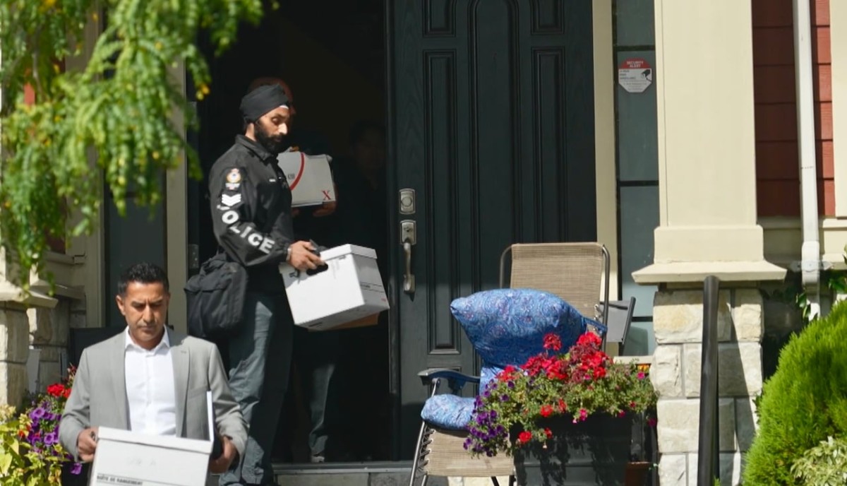 Vancouver police officers remove boxes from a residence as part of an investigation