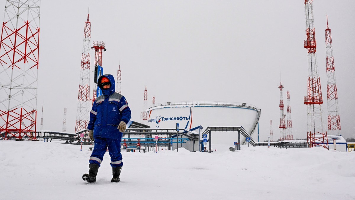 A worker walks through snow past storage tanks and towers at a Russian oil pipeline facility, the kind of infrastructure the new sanctions bill targets. Photo: NBC News
