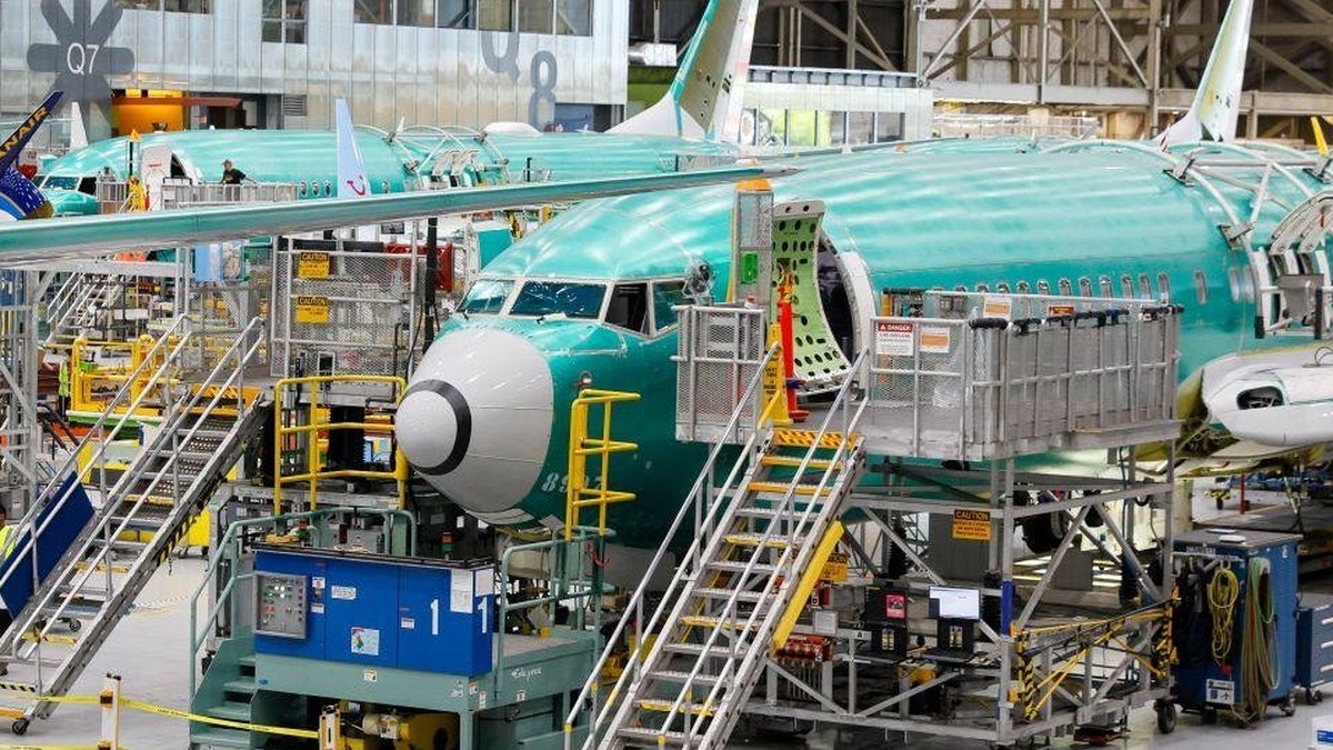 A Boeing 737 MAX on the assembly line inside the manufacturer's factory, with workers and tooling alongside the airframe. Photo: Getty Images