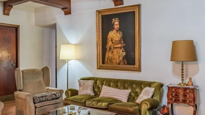 The Portrait of a Lady hangs above a green sofa in the Mar del Plata living room where it was found