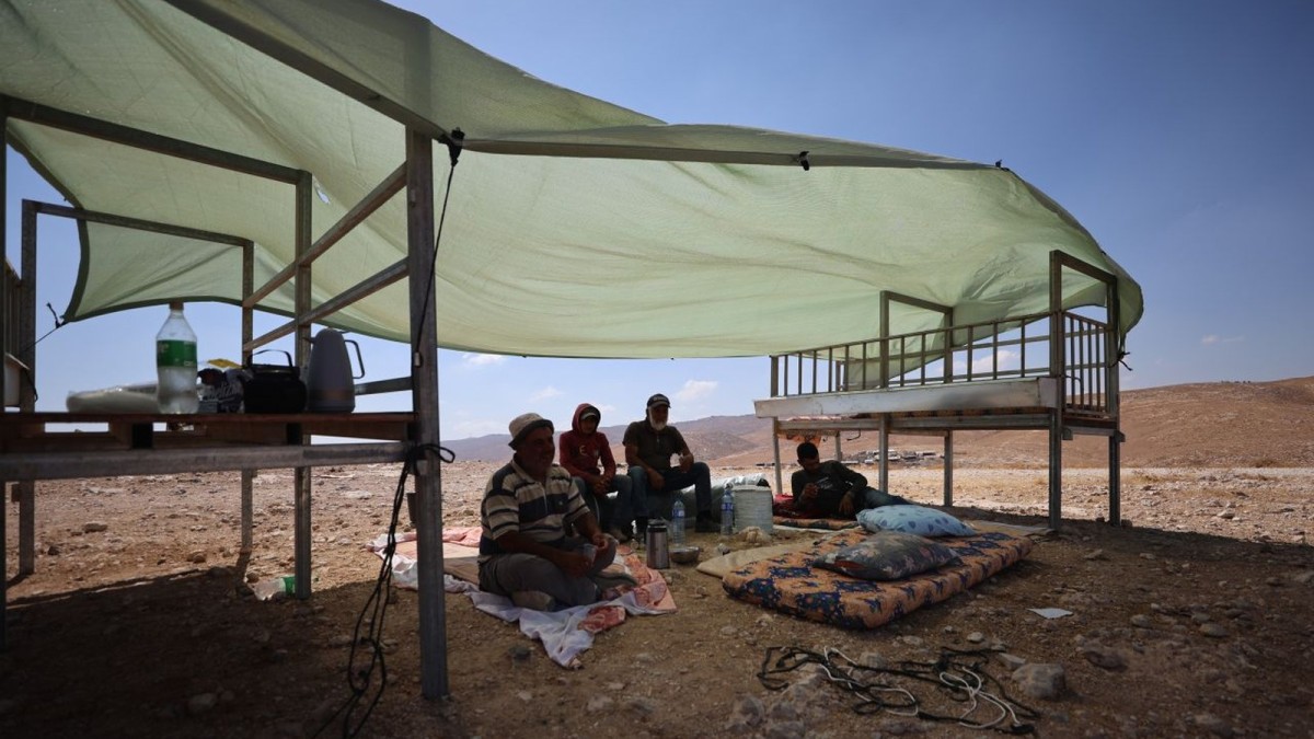 Residents clear debris from homes and livestock pens in Khirbet al-Tabban, Masafer Yatta, after the demolition (Al Jazeera)