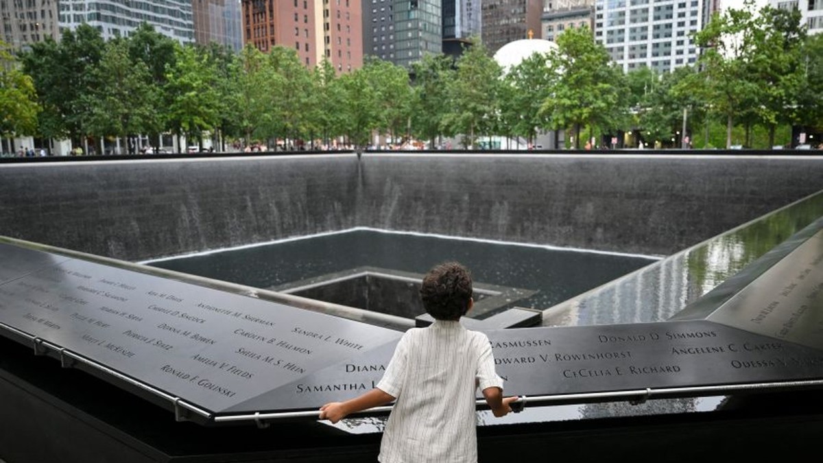 A child looks at the south tower reflecting pool memorial at the National 9/11 Memorial and Museum in New York.