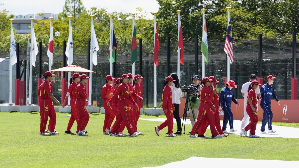 Athletes pass a row of national flags at the 20th Asian Games in Aichi-Nagoya, Japan, which opened on September 19, 2026, as organisers prepared for Typhoon Dujuan. Photo: Kyodo News