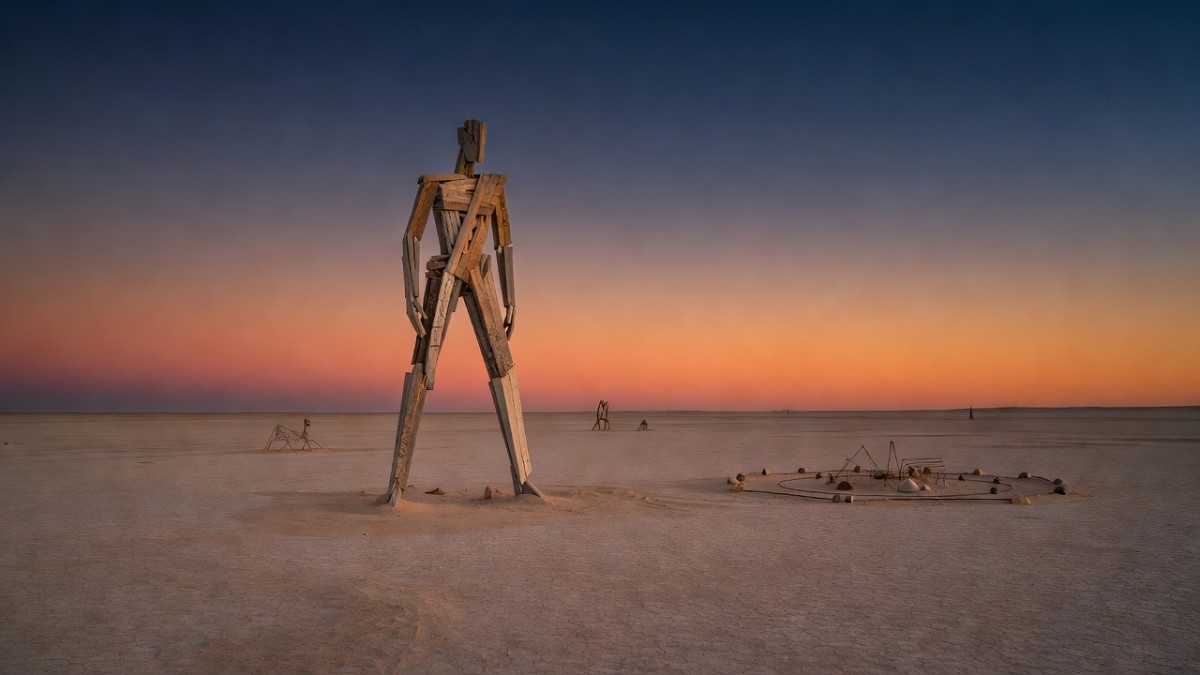 The Man effigy and art installations stand on the Black Rock Desert playa at dusk