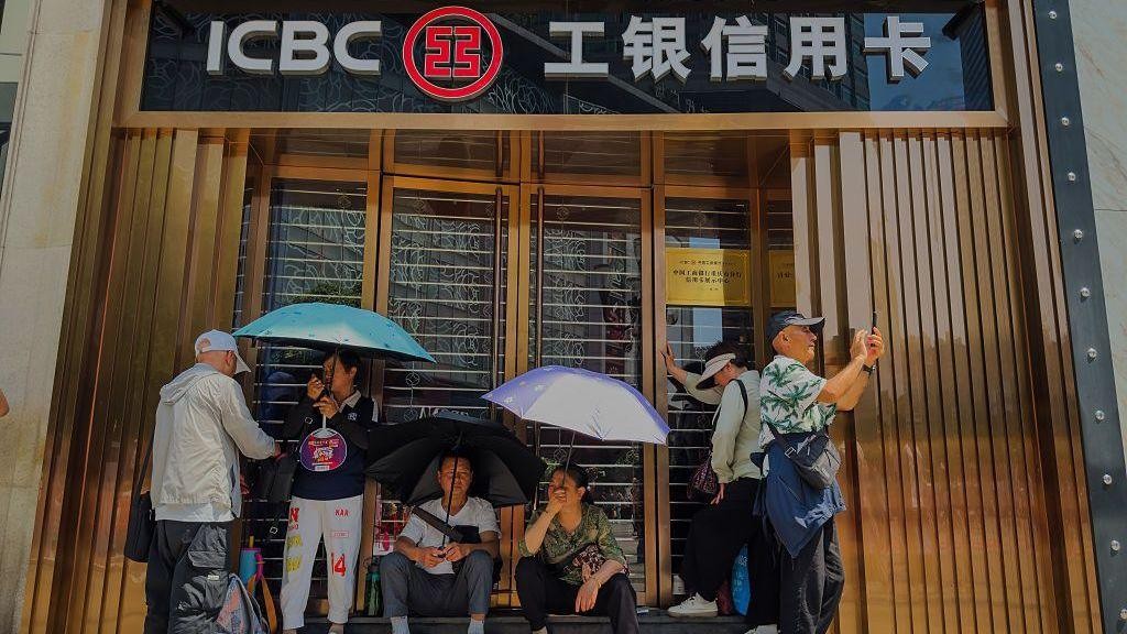 People rest outside a closed ICBC credit card service centre in Chongqing