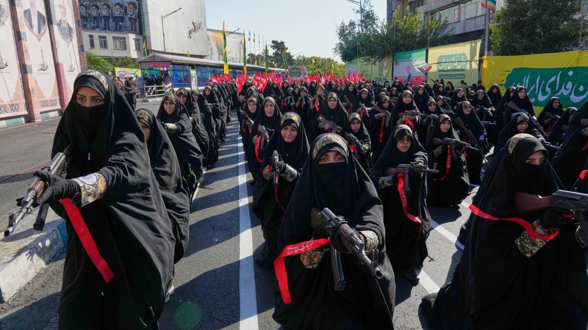 Women affiliated with Iran’s Revolutionary Guard carry rifles during the state-organized 
